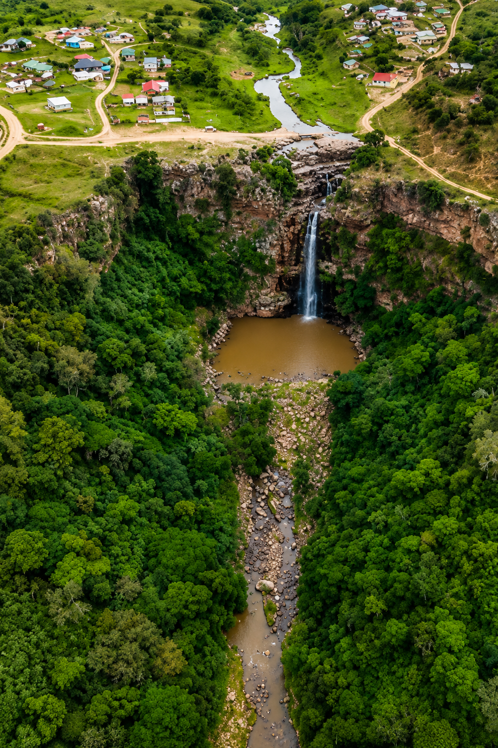 Aerial view of a waterfall dropping into a forested gorge near Inanda